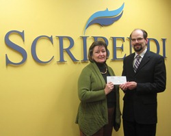 Female representative from Mary Webb Cultural and Community Centre accepting a check from the Vice-President of Scribendi.com.