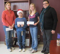 Two adults and two children stand with cheques donated by Scribendi.com to the McFadden fundraiser.