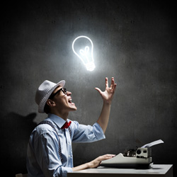 An author screenwriting on his type writer has a bright light bulb over his head.