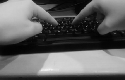 Two fingers are poised over a computer keyboard.