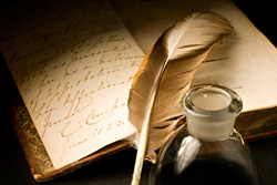 A feather pen and ink sit on a pad of paper explaining how to write a script.