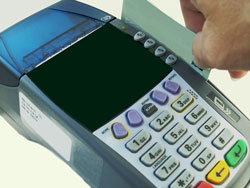 An American express card is being run through a credit card terminal. American express is one of the payment options available at Scribendi.com.