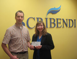 Randall Van Wagner, from the Lower Thames Valley Conservation Authority, and Scribendi.com President Chandra Clarke, stand together in front of the Scribendi sign holding a donation.